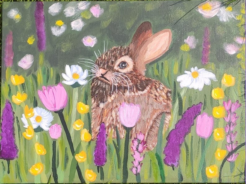 May include: An acrylic painting on canvas depicting a brown rabbit with long ears positioned in a vibrant meadow. The scene is filled with colorful wildflowers including white daisies, pink tulips, and tall purple spikes of lavender against green grass.
