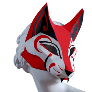 Peut inclure: Un masque de renard rouge et noir avec des accents blancs et un design stylis&eacute;. Le masque est en papier et a une forme tridimensionnelle.