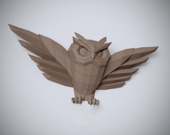 Op de afbeelding: Een bruine papieren uil met uitgespreide vleugels. De uil is gemaakt van gevouwen papier en heeft een geometrisch ontwerp.