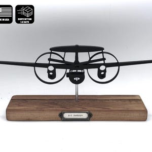 May include: Black metal model of a B-25 bomber airplane on a wooden base with a metal plaque that reads "B-25 Mitchell".