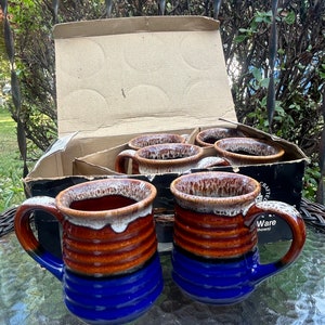 May include: Set of six brown and blue ceramic mugs with white glaze. The mugs have a textured, ribbed design. The mugs are in a cardboard box with the words "Crafted Ware (shown)" printed on the side.