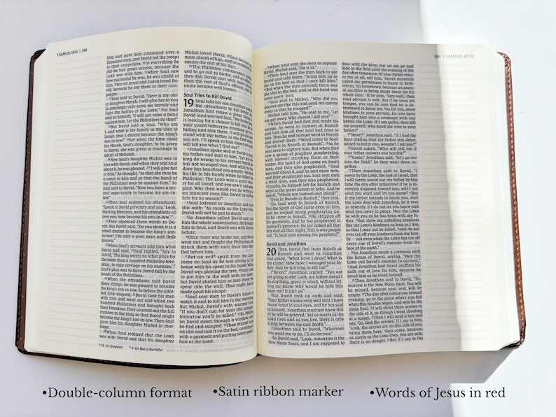May include: Open Bible with double-column format, satin ribbon marker, and text in red. The book has a brown leather cover and is open to a page with printed text. The text includes the words of Jesus in red.