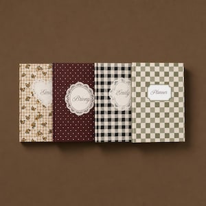 May include: Four rectangular hardcover journals arranged side-by-side. The first features a beige floral gingham pattern with a heart-shaped label reading Emily. The second is dark red with white dots and a circular label reading Briony. The third has a black and white buffalo check pattern with a circular label reading Emily. The fourth has a sage green and white checkerboard pattern with a rectangular label reading Planner.