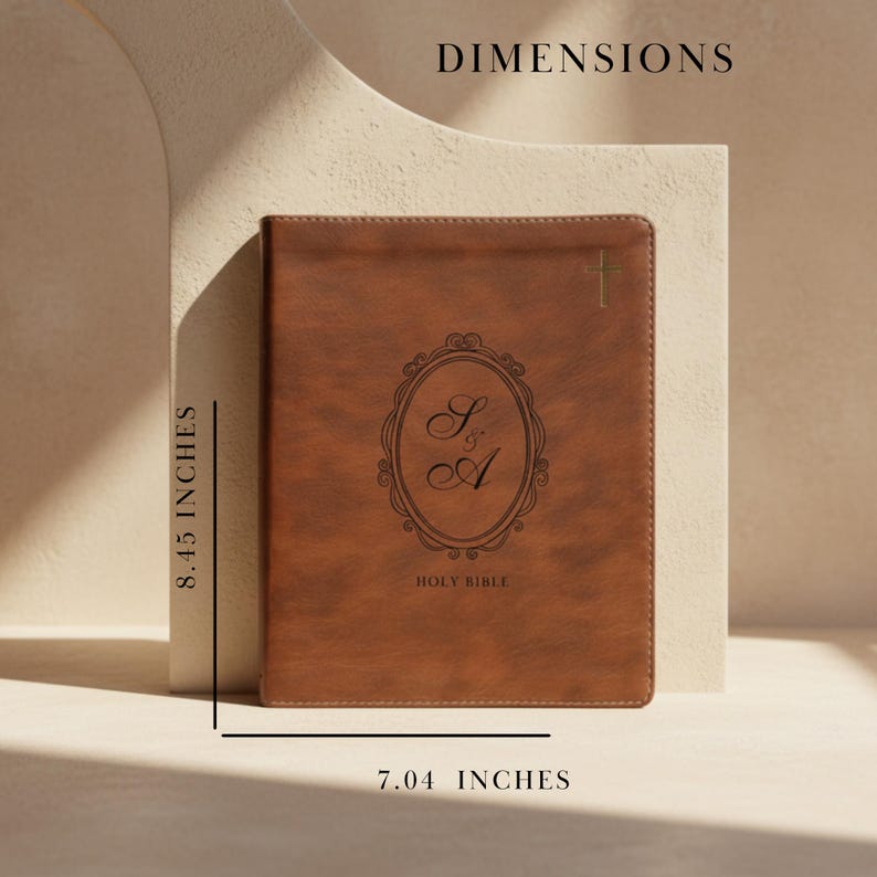 May include: A brown leather Holy Bible with gold cross and monogram. The book measures 8.45 inches high and 7.04 inches wide. The cover features an oval design with the initials "S" and "A". The words "Holy Bible" are printed at the bottom.