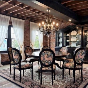 May include: A dining room set with a round wooden table and six chairs. The chairs have patterned upholstery and dark wooden frames. A black cabinet displays white plates. Sheer white curtains frame the windows.