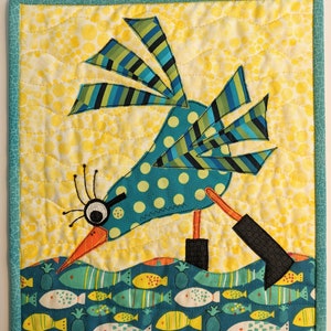 May include: A whimsical blue and green bird with polka dots and striped wings is perched on a yellow background. The bird is looking down at a school of colorful fish swimming in a blue and green sea.