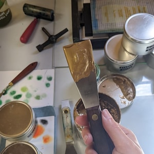 Gold ink on a palette knive in letterpress studio