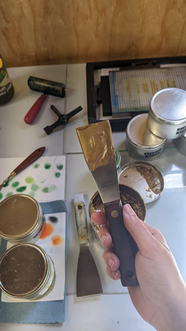 Gold ink on a palette knive in letterpress studio