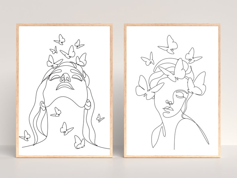 May include: Two black and white line art prints of a woman's face with butterflies around her head. The woman in the left print has butterflies around her head and neck. The woman in the right print has butterflies around her head and shoulders.