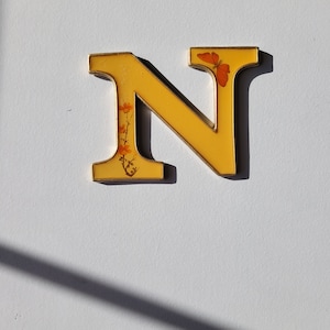 Letra N chapada en oro esmaltada en amarillo con flor naranja y mariposa, decoración vintage para el hogar de los años 60