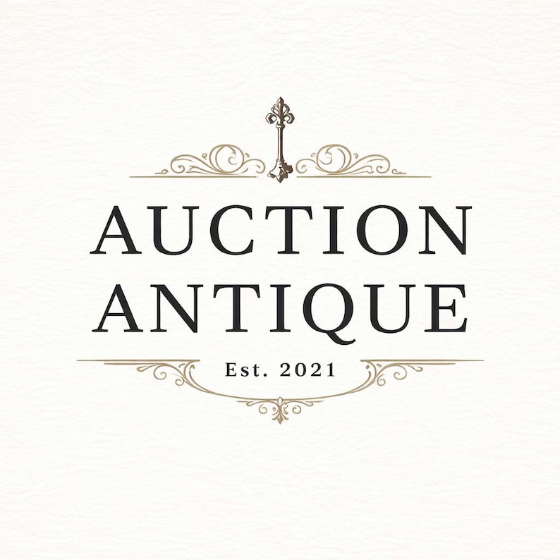 May include: Logo for "Auction Antique" in black text with decorative flourishes and a key icon. The text "Auction Antique" is centered, with "Est. 2021" below. The design is on a cream-colored background.