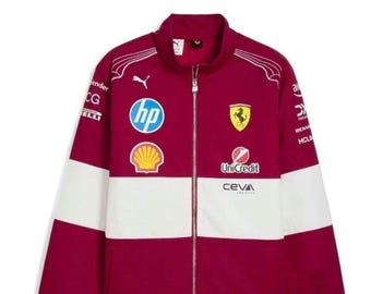 May include: A deep red and white zip-up jacket featuring various sponsor logos including HP, Shell, Ferrari, UniCredit, and Ceva Logistics. The garment has a high collar, a silver zipper, and white Puma branding on the upper chest area.