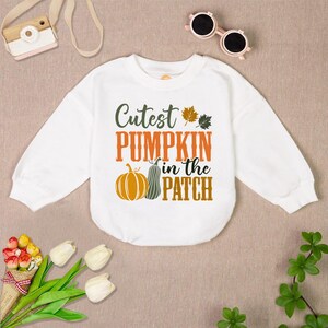 May include: White long-sleeve sweatshirt with the text "Cutest Pumpkin in the Patch" and a graphic of two pumpkins.