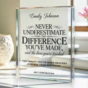 May include: A clear acrylic block with the text "Emily Johnson NEVER UNDERESTIMATE THE DIFFERENCE YOU'VE MADE, and the lives you've touched." The text is in black, with a decorative font. The bottom reads "THE IMPACT YOU'VE MADE REACHES FURTHER THAN YOU KNOW. ABC CORPORATION."