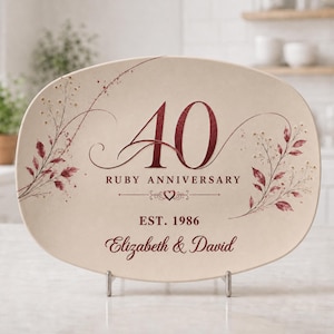 May include: An oval-shaped cream-colored plaque featuring the dark red text 40 RUBY ANNIVERSARY, EST. 1986, and the names Elizabeth & David. The design includes delicate dark red floral illustrations on both sides and a small heart icon.