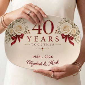 May include: An oval-shaped cream-colored plaque featuring the text 40 YEARS TOGETHER in dark red, flanked by illustrations of cream roses and red ribbons. The plaque includes the years 1986 - 2026 and the names Elizabeth & Mark in red script.