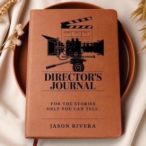May include: A brown leather-bound Director's Journal with a black film camera and clapperboard graphic. The journal includes the text "Director's Journal" and "For the stories only you can tell." The name "Jason Rivera" is printed at the bottom.
