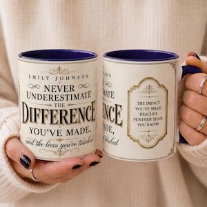 May include: A cream-colored ceramic mug with a dark blue interior and handle. The front features the text "Emily Johnson Never Underestimate The Difference You've Made, and the lives you've touched" in black and gold decorative lettering.