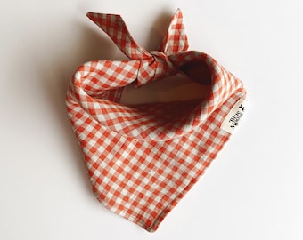 May include: Orange and white gingham dog bandana with a "Blue Moose" label.
