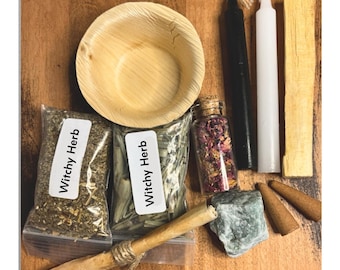 May include: A collection of items including a round palm leaf bowl, two plastic bags labeled Witchy Herb, a glass vial filled with dried flower petals, one black candle, one white candle, a palo santo stick, a green stone, and two incense cones.