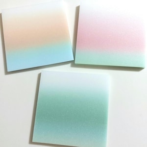 May include: Three square sticky notes with a gradient color design. The top note is white fading to light peach, then light blue. The middle note is white fading to light pink, then light green. The bottom note is white fading to light blue, then light green.