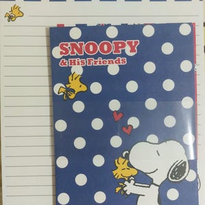 Juego de letras de Snoopy y Woodstock con línea roja y puntos azules
