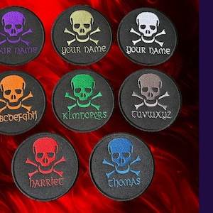 May include: Eight 80mm round black morale patches with a white skull and crossbones design. Each patch has a different coloured embroidered text, including "your name", "ABCDEFGH", "KLMNOPQRS", "tuvwxyz", "harriet", and "thomas". The patches are hook backed and can be personalised with up to 12 characters.