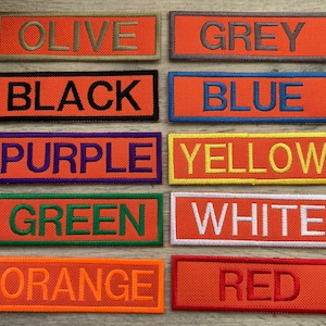以下が含まれることがあります： 異なる色とテキストのファブリックパッチが10枚。色はオリーブ、グレー、ブラック、ブルー、パープル、イエロー、グリーン、ホワイト、オレンジ、レッド。パッチのテキストは「OLIVE」、「GREY」、「BLACK」、「BLUE」、「PURPLE」、「YELLOW」、「GREEN」、「WHITE」、「ORANGE」、「RED」です。