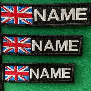 May include: Three black and white embroidered patches with the Union Jack flag and the word "NAME" in white lettering.