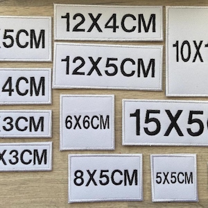 Könnte beinhalten: Zehn weiße Stoff-Patches mit schwarzem gesticktem Text, der verschiedene Größen in Zentimetern angibt. Die Größen sind: 10x5cm, 10x4cm, 10x3cm, 8x3cm, 12x4cm, 12x5cm, 6x6cm, 8x5cm, 10x10cm, 15x5cm, 5x5cm, 5x3cm.