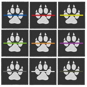 May include: Nine embroidered patches featuring a white paw print with a thin coloured line across the middle. The line colours are blue, red, yellow, green, orange, purple, grey, silver, and green.