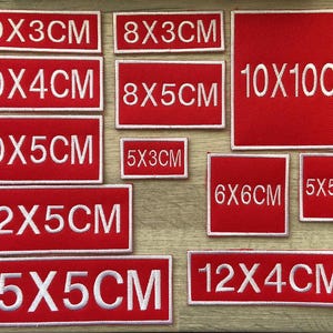 May include: A set of ten red fabric patches with white text indicating different sizes in centimetres. The sizes include 10x3cm, 8x3cm, 10x4cm, 8x5cm, 10x10cm, 10x5cm, 5x3cm, 6x6cm, 5x5cm, 12x5cm, 15x5cm, and 12x4cm.