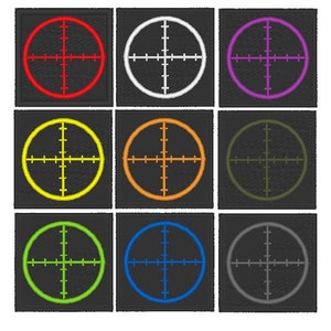 May include: Nine different colored target sights with a black background. The targets are red, white, purple, yellow, orange, green, lime green, blue, and gray.