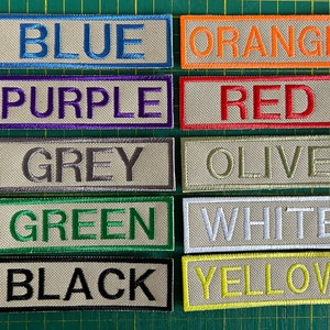 May include: A set of ten fabric patches with different colors and the color name embroidered on each patch. The colors are blue, orange, purple, red, grey, olive, green, white, black, and yellow.