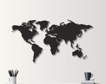 Pode incluir: Uma decoração de parede de mapa do mundo de metal preto com uma sombra projetada na parede atrás dela. O mapa está montado em uma parede branca.