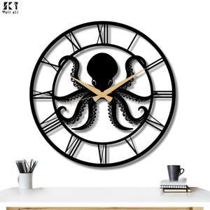 Könnte beinhalten: Schwarze Wanduhr mit Oktopus, goldenen Zeigern und römischen Ziffern. Die Uhr hat ein schwarzes Oktopus-Design in der Mitte, wobei die Zeiger auf 2:10 Uhr zeigen. Die Uhr ist ein dekoratives Wandkunstwerk.