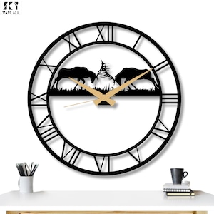 Könnte beinhalten: Schwarze Metall-Wanduhr mit römischen Ziffern und einer Silhouette von zwei kämpfenden Elchen. Die Zeiger sind goldfarben, das Zifferblatt weiß. Dekorative Wandkunst.