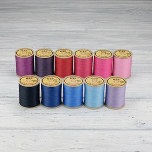 May include: Ten spools of thread in various colors, including purple, red, pink, blue, and black. Each spool is labeled with the number "632" and the brand name "DMC".