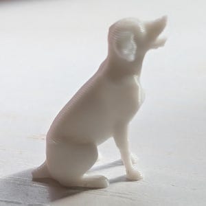 White  3D printed figurine of a Labrador Retriever dog sitting, white background, side view