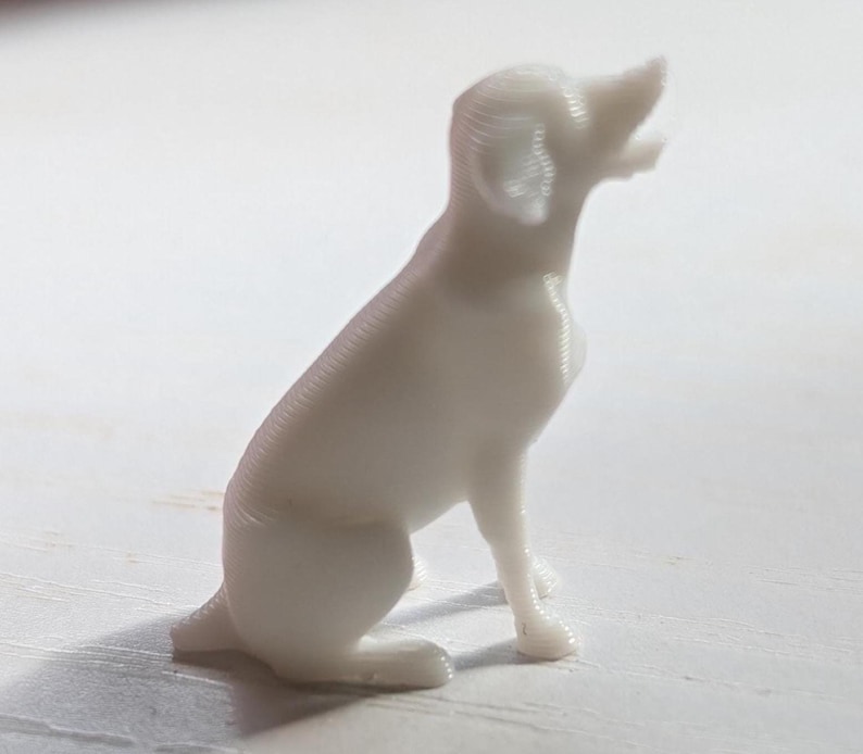 White  3D printed figurine of a Labrador Retriever dog sitting, white background, side view