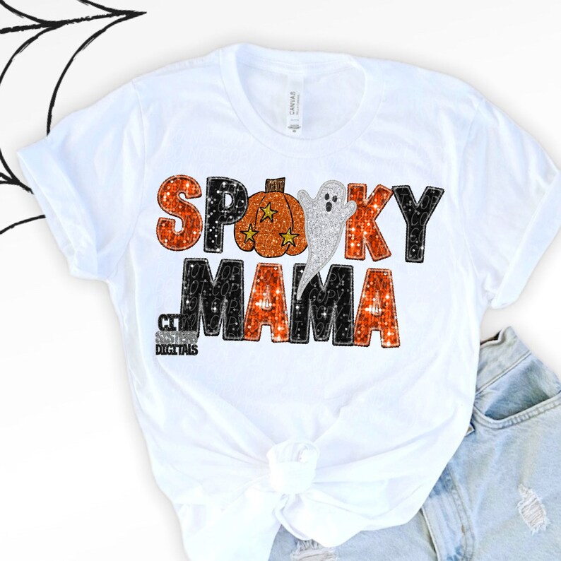 Puede incluir: Una camiseta blanca de manga corta con el texto SPOOKY MAMA en un patr&oacute;n brillante de color naranja y negro. La letra O est&aacute; sustituida por una calabaza naranja con estrellas amarillas y un fantasma blanco entre las palabras.