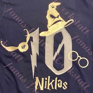 Pu&ograve; includere: Una maglietta blu navy con un design glitter oro che presenta il numero 10, un fulmine, un Cappello Parlante, un Boccino d'Oro e il testo "Niklas".