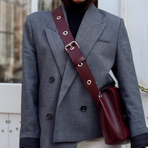 Burgunderfarbene Crossbody handgefertigte Tasche mit Metalldetails.