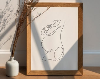 May include: A framed line drawing of a pregnant person in a minimalist style. The drawing is in black ink on white paper and is framed in a natural wood frame.
