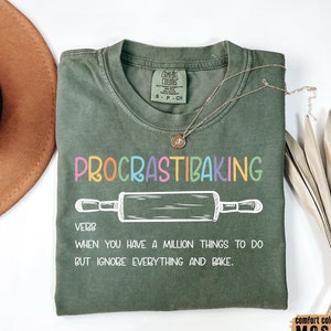 May include: A green t-shirt with the text "PROCRASTIBAKING" in rainbow colors. The text is defined as a verb: "When you have a million things to do but ignore everything and bake."