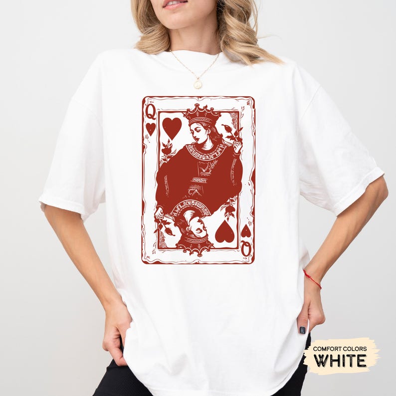 May include: White t-shirt with a red graphic of the Queen of Hearts playing card. The card features a stylized illustration of the Queen holding a heart and a crown.