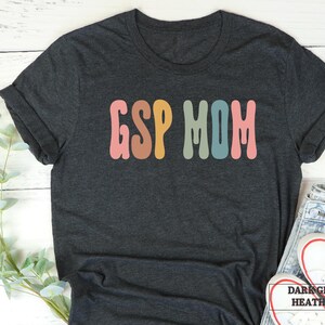 a t - shirt with the word g s mom in multicolored letters