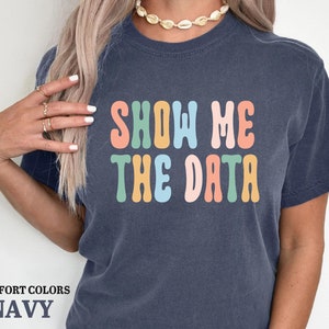 a woman wearing a t - shirt that says show me the data