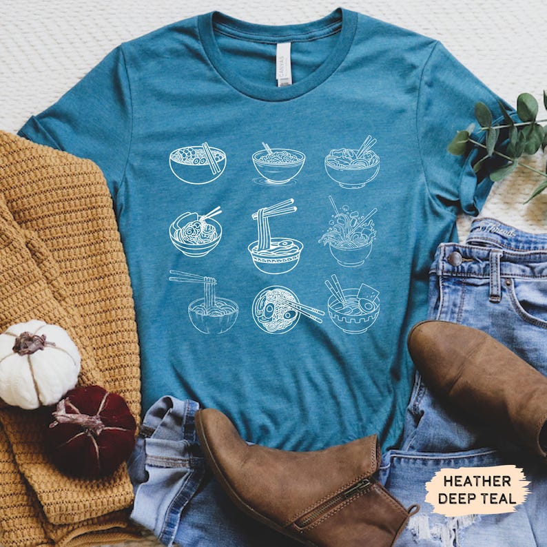 May include: A teal blue t-shirt with a white graphic of nine bowls of noodles. The text "HEATHER DEEP TEAL" is in the bottom right corner of the image.