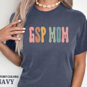 a woman wearing a navy tshirt with the word g is for mom printed